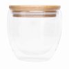 Dwuścienna szklanka BAMBOO ART S z pokrywą z bambusa. Przezroczysta, odporna na temperaturę, o pojemności ok. 250 ml. P006284I